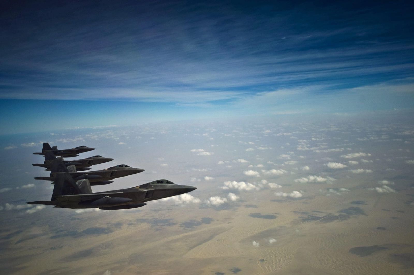 Fighter jets flying in formation above the clouds