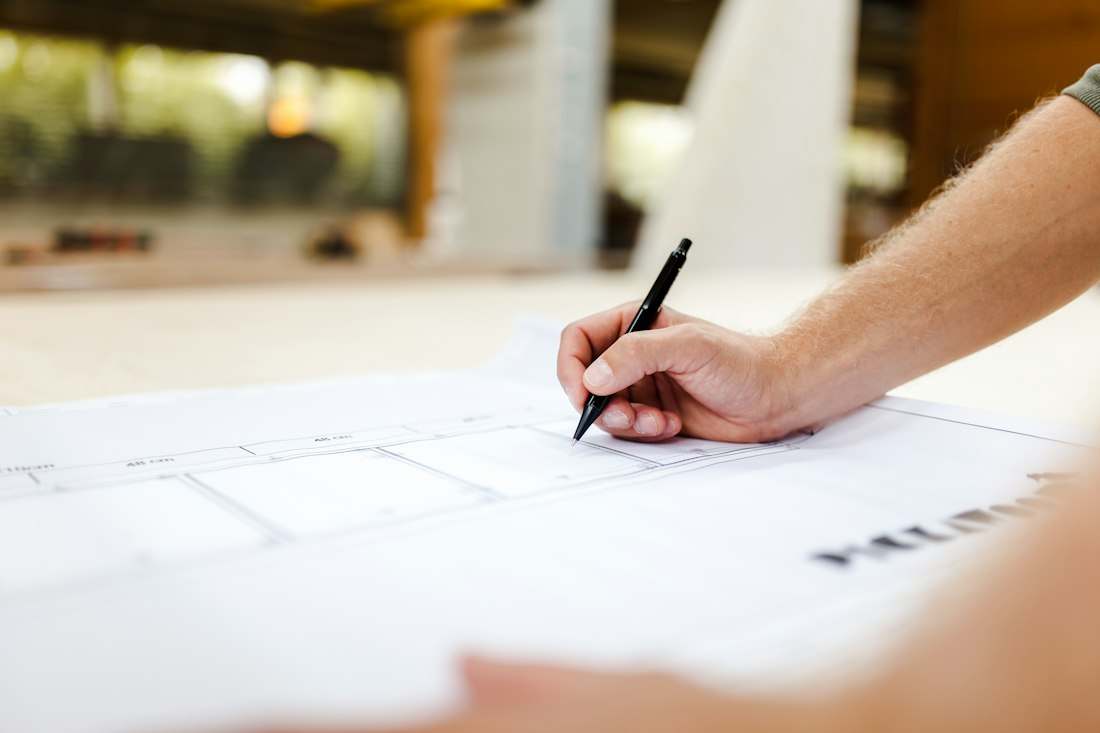 Person drawing plans at a desk