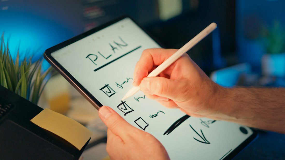Person writing a plan on a tablet