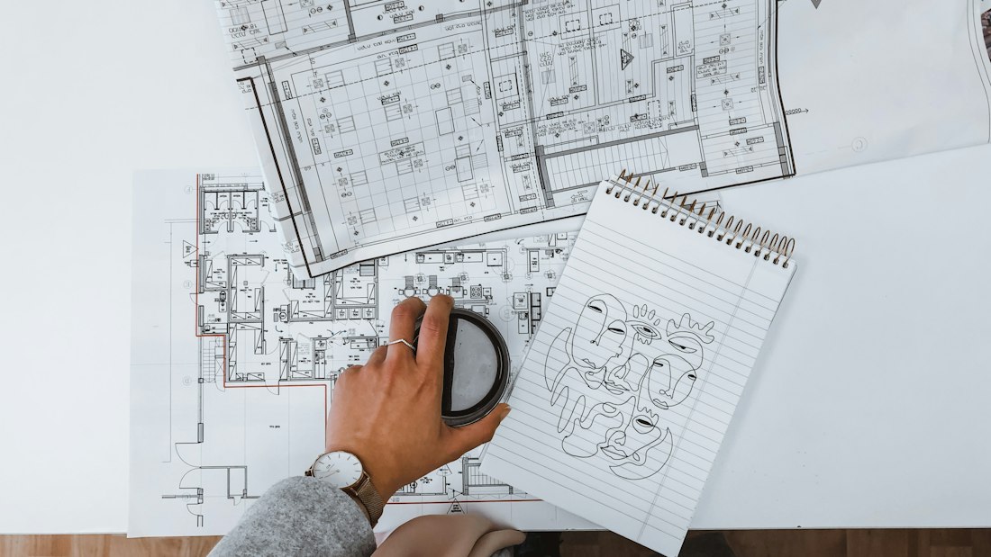 Person holding a magnifying glass over documents