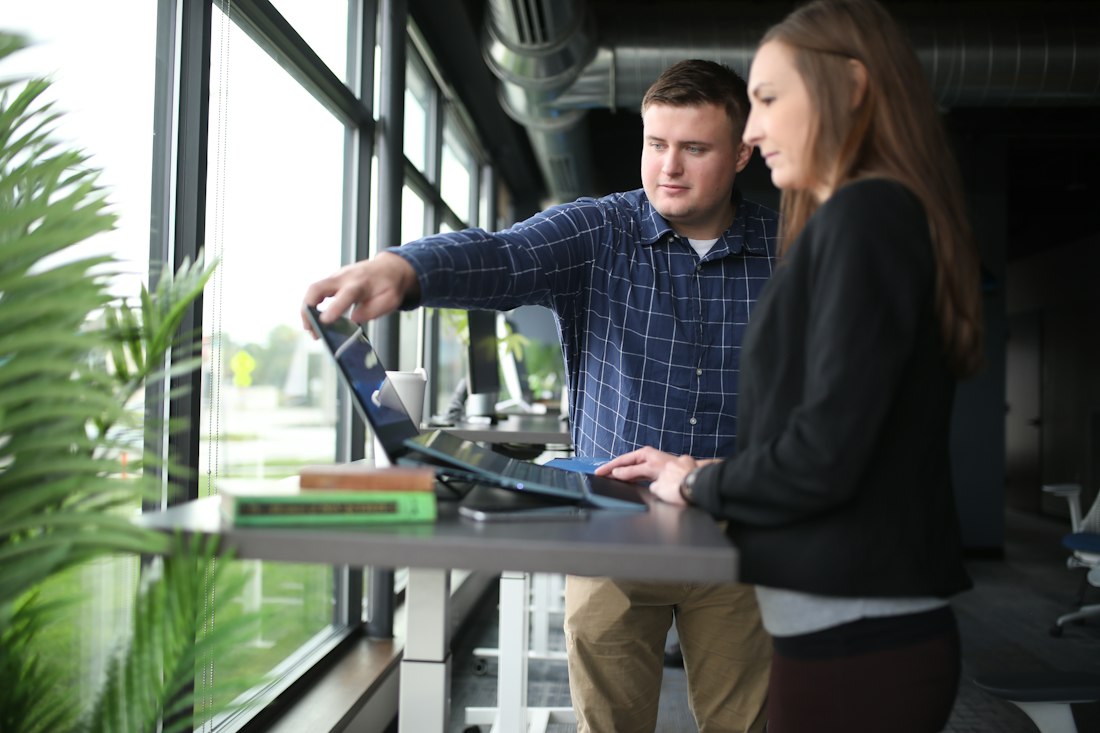 Two colleagues reviewing a laptop together